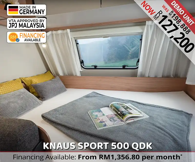 Front double bed in Knaus Sport 500 QDK caravan with soft lighting and privacy partition.